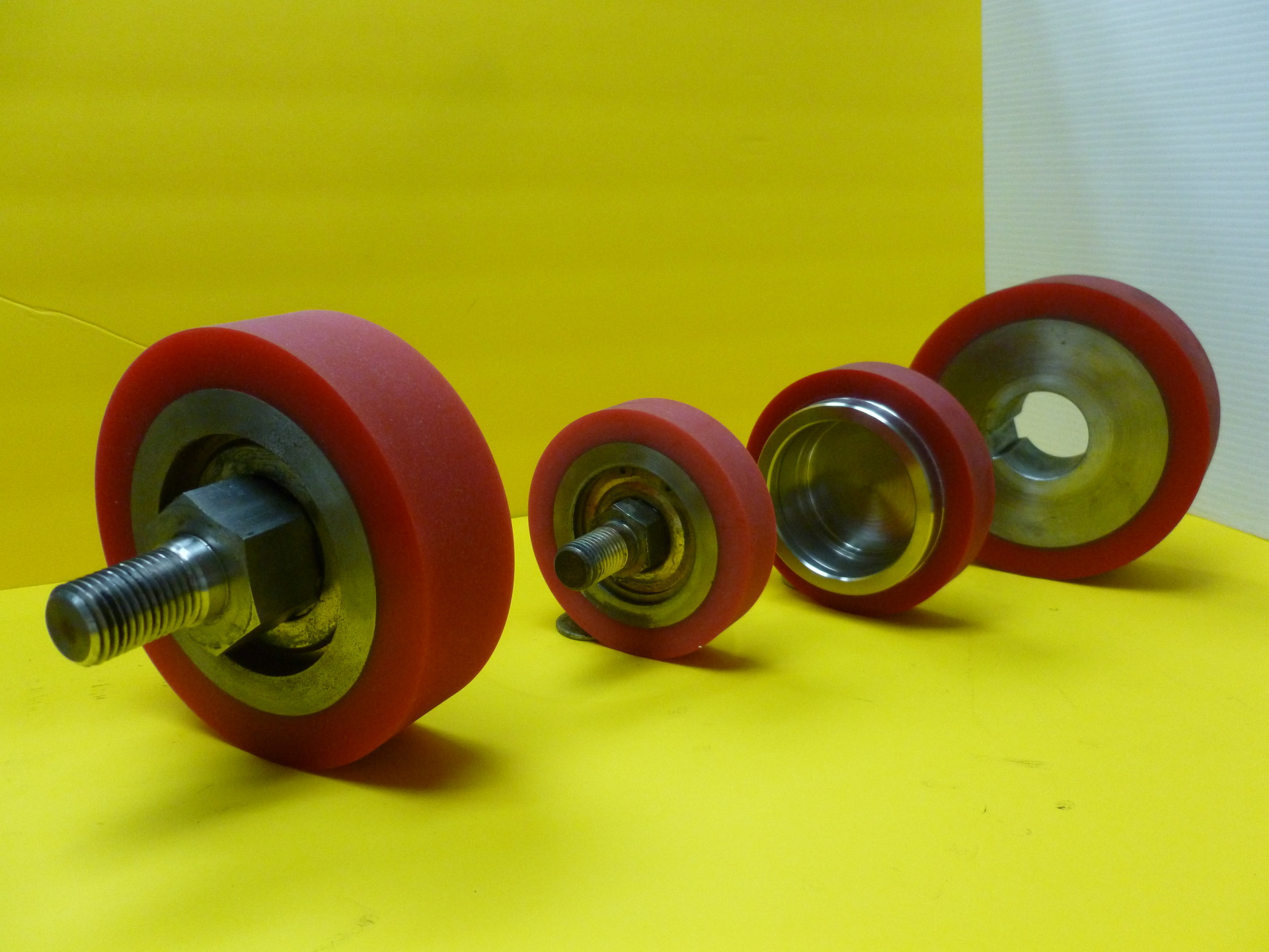 Red urethane festoon wheels manufactured by Parkway-Kew, mounted on their shafts